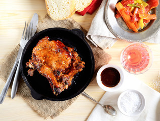 pork steak in a frying pan, fried vegetables