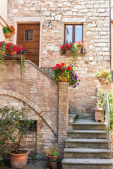 Fototapeta na wymiar Ingresso romantico di abitazione storica con vasi di fiori