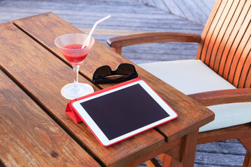 cocktail, touch pad and glasses on beach
