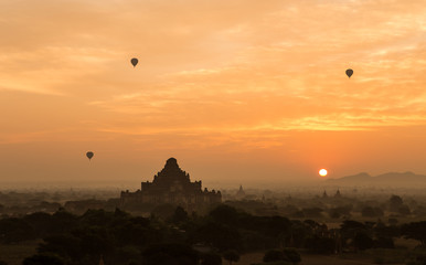 Hot air balloon float over silhouette ancient temple with scenic sunrise orange sky at Old Bagan , Myanmar