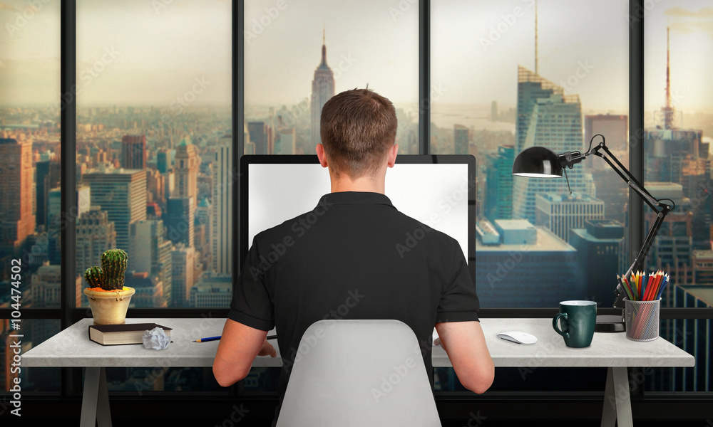 Poster man work on office computer with isolated screen for mockup. office with a view of the skyscrapers. 