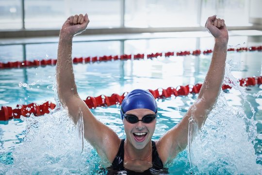 Fit woman triumphing with raised arms