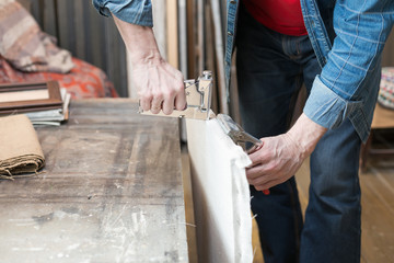 Closeup of an artist's hands crafting canvas. Selective focus