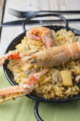 Vegetable paella with seafood on a wooden background