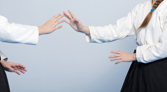 Hands of two girls in black hakama practice Aikido on martial arts training