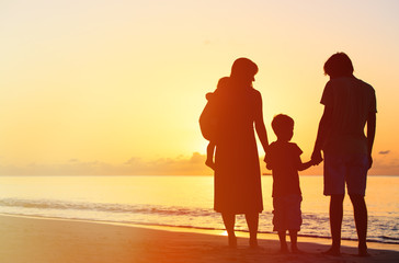 Fototapeta na wymiar happy family with two kids at sunset