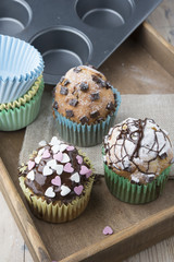 Photo of tasty cupcakes with chocolate over wooden table