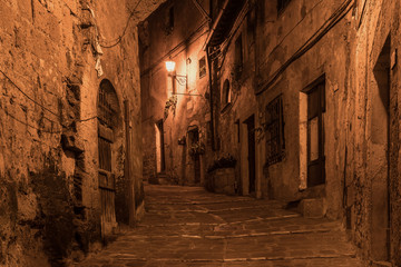Street of ancient medieval tuff city Sorano at night  - travel european background
