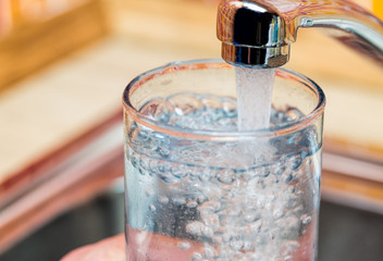 Een glas vullen met drinkwater uit de keukenkraan