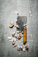 Fragrant cloves of garlic and a large hatchet.
