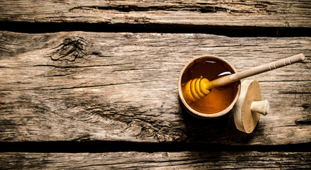 Natural honey in wooden barrel with spoon.