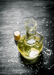 Fresh olive oil in glass jar. On black rustic background.