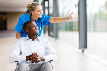 healthcare worker taking disabled patient for a walk