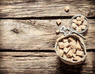 Cane sugar refined in the bag. On wooden background.