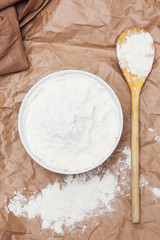 plate and wooden spoon with flour on paper