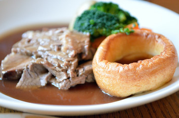 Traditional Sunday roast beef dinner with Yorkshire puddings and gravy..