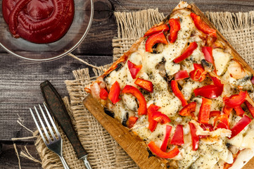 Portion of pizza on wooden background, top view.