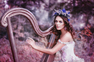 beautiful brown-haired woman with a flower wreath on her head, wearing a white dress playing the...