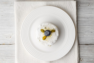 Cake with pistachio and blueberry on the white wooden table top view