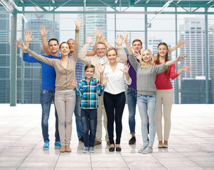 group of smiling people waving hands