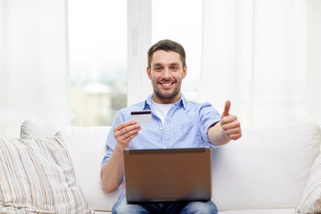 man with laptop and credit card showing thumbs up