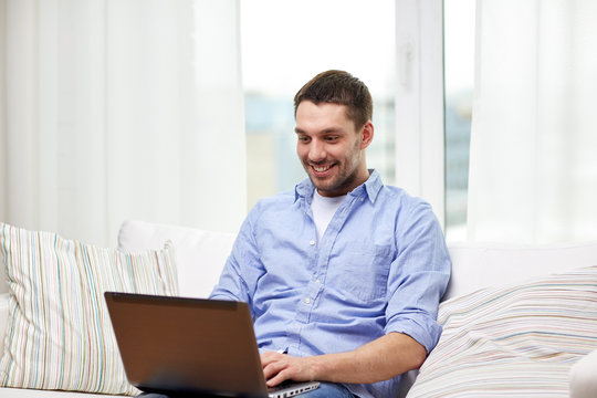 smiling man working with laptop at home
