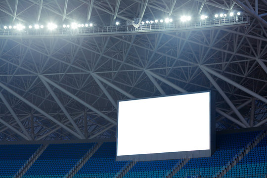 Blue seats and electronic billboard display at stadium