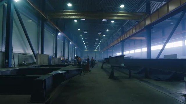 Footage of a heavy industry factory with workers and flying sparks. Shot on RED Cinema Camera.