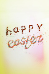 Happy Easter phrase made from raisins and colorful baking sugar over colorful background