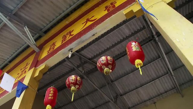 Chinese lanterns hanging below a sign in Chinese.