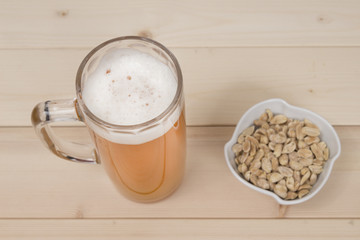 Mug of beer and peanuts in the bowl. Studio shoot