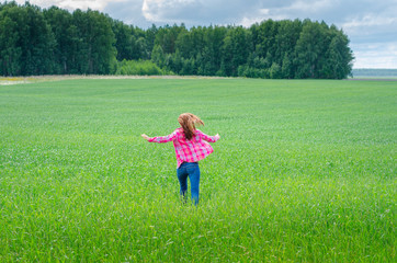 female runs on a field of wheat