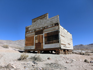 Old vintage western wooden shack in desert - landscape color photo