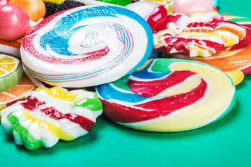 Colorful sweets and candies on a green background