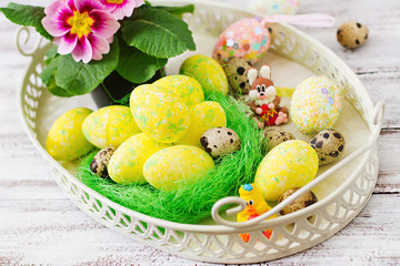 Easter eggs and flowers on a light wooden background