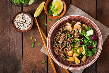 Miso and soba noodle soup with roasted tofu and mushrooms. Top view