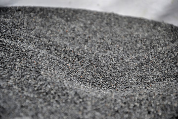 Close up of a pile of fresh harvested poppy seeds spread in bowl, ready for drying, macro photo. Ingredient for baking