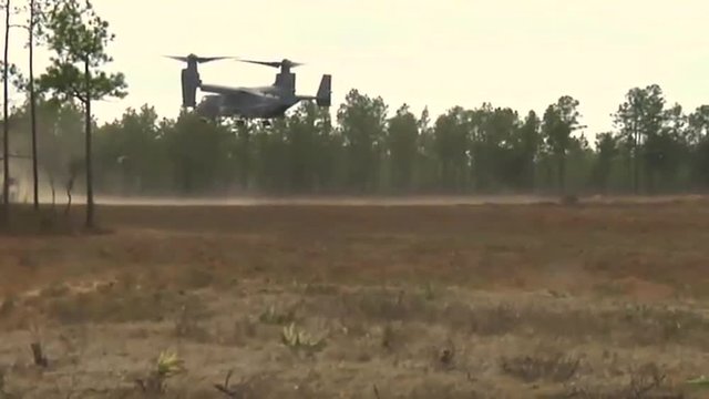 The Osprey CV-22 helicopter lands in a field.