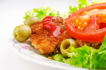 Pork chop with salad and olives on a light background
