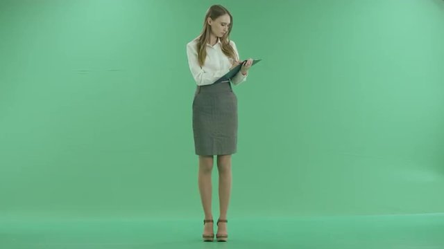happy business woman writes document on green screen