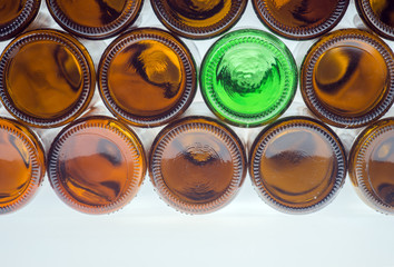 Grüne Bierflasche zwischen braunen Bierflaschen