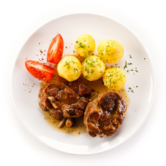 Grilled steaks, boiled potatoes and vegetable salad 