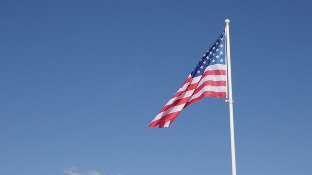 American flag fabric in slow motion waving on the wind 1920X1080 HD footage - United States of America flag against blue sky flowing slow-mo 1080p FullHD video 