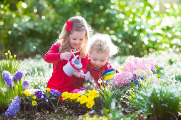 Kids planting flowers in blooming garden