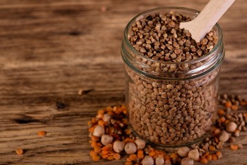 Glass dose full of buckwheat with other legumes around