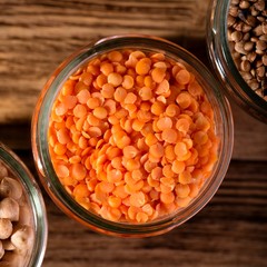 Top view on glass with red lentils and next legumes