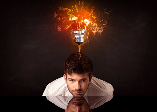 Businessman sitting under a blowing idea bulb
