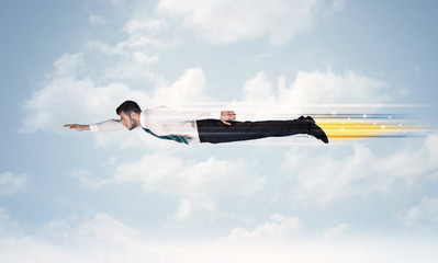 Happy business man flying fast on the sky between clouds