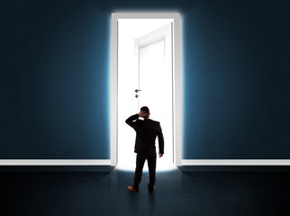 Fototapeta premium Business man looking at big bright opened door