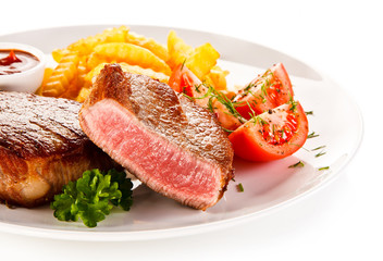 Grilled beefsteaks and vegetables